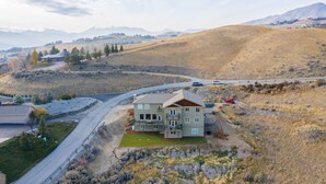 A multi-story house with a driveway and a road nearby. - Luxury Home with Epic Views - Game Rooms, Gym, Near Leavenworth &
Lake Chelan (Wenatchee)