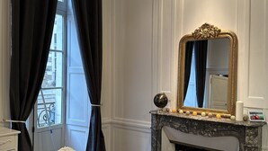 A room with a fireplace, a mirror, and a dining table with placemats.