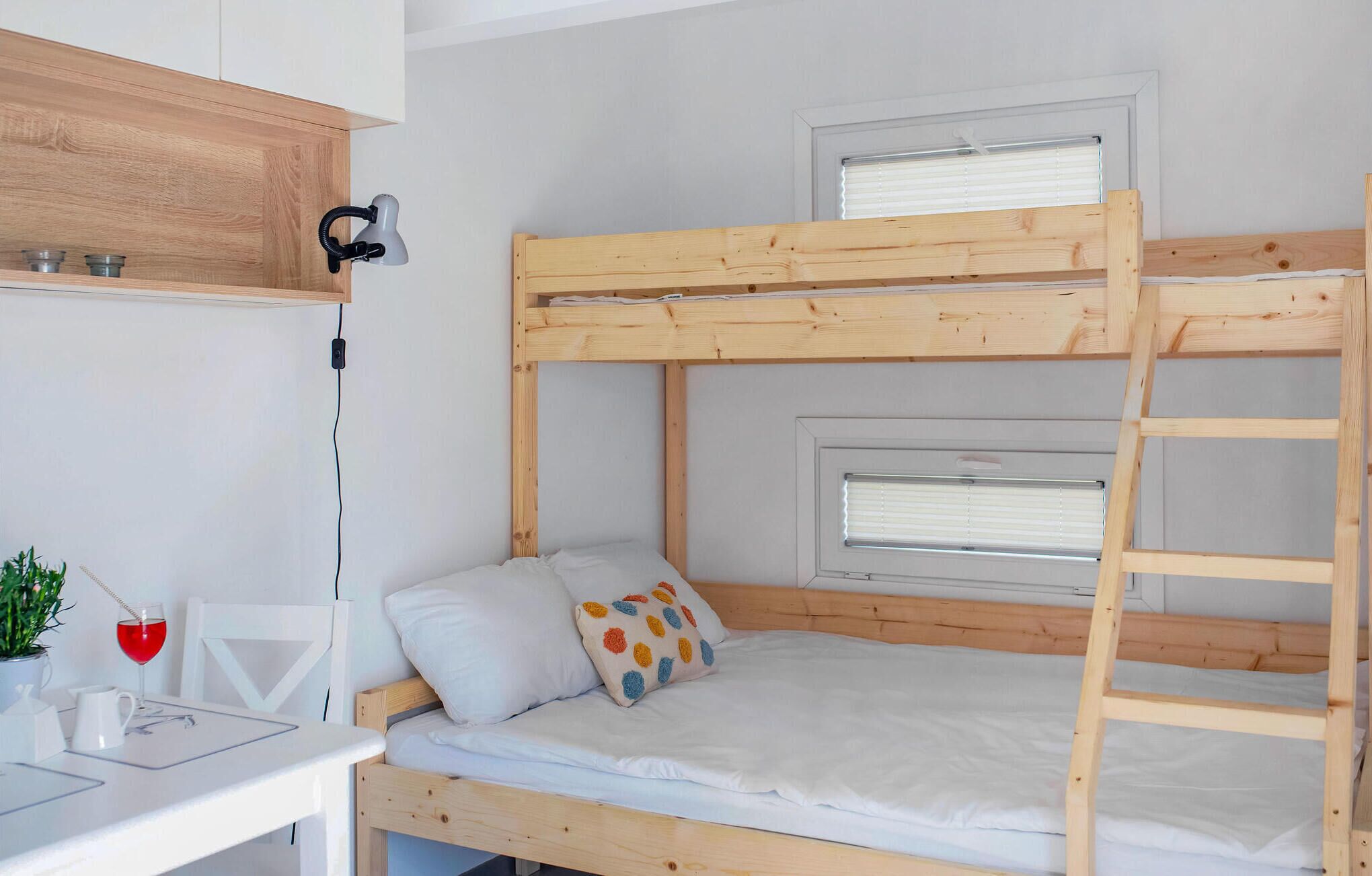 Una cama litera con escritorio y ventana.