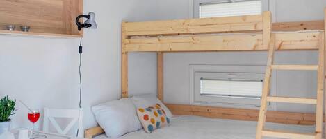 Una cama litera con escritorio y ventana.