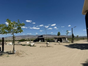 A desert campground with tents, a dirt road, and sparse vegetation. - Lakeside Tent Site#1 Death Valley Passageway (Olancha)