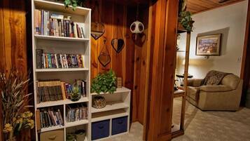 A cozy living room with a bookshelf, a sofa, and a coffee table.
