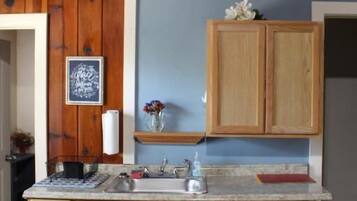 A kitchen with wooden cabinets, a marble countertop, and a small island.