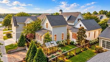 A residential area with multiple houses, a greenhouse, and a well-maintained lawn.