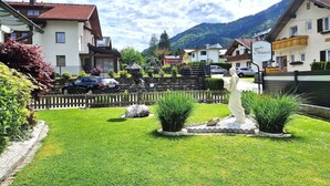 A residential area with houses, a statue, and a mountain in the background. - Comfortable Apartment Near Nassfeld (Hermagor-Pressegger See)