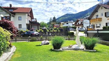 A residential area with houses, a statue, and a mountain in the background.
