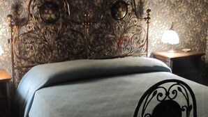 Un lit avec une tête de lit en métal et une table de chevet avec une lampe.