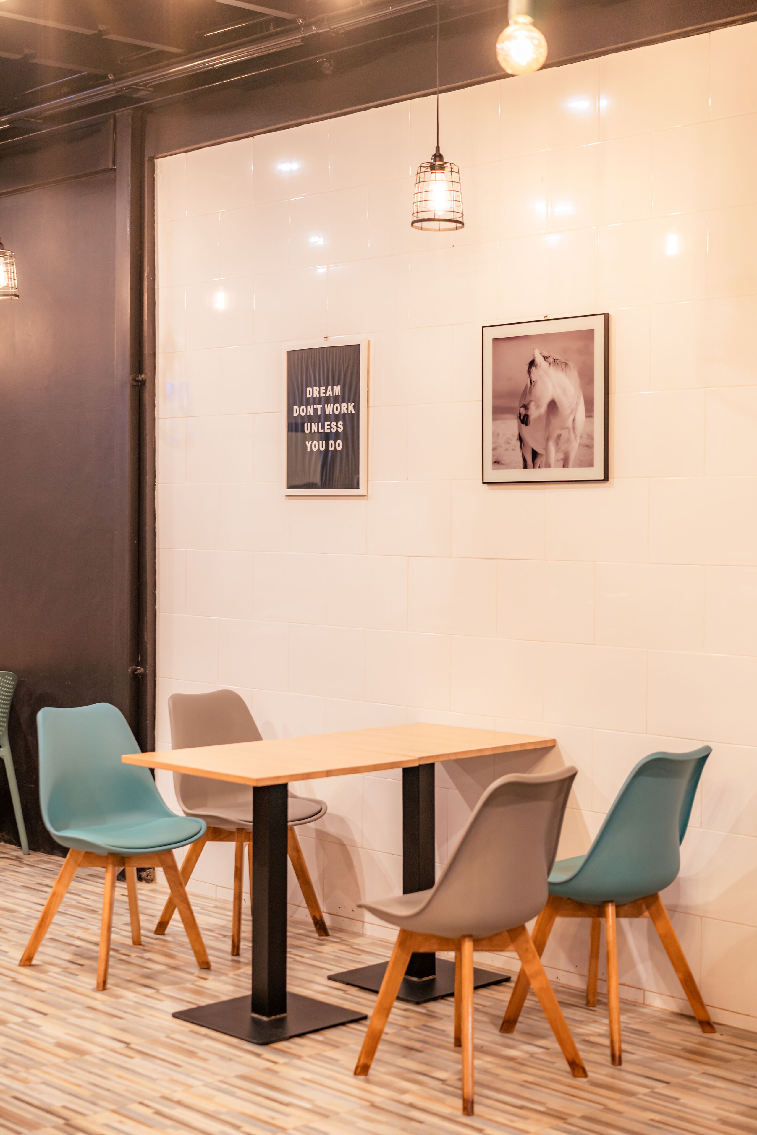Une salle de conférence avec une table en bois et quatre chaises, un cadre contenant une citation inspirante et une photographie encadrée accrochée au mur.