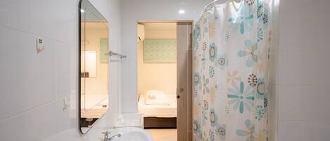 A bathroom with a white sink, a mirror, and a shower curtain with a floral pattern.