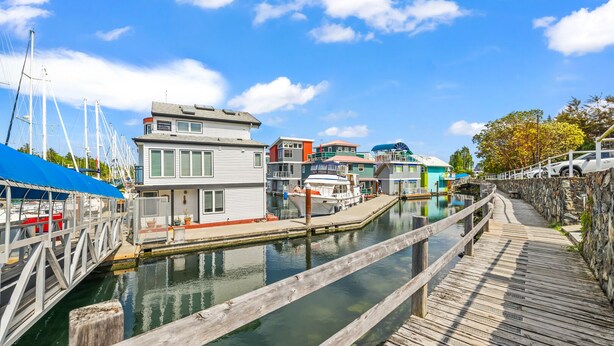 A waterfront property with a dock, a wooden walkway, and a marina with boats. - West Bay Bliss (Victoria)