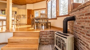 Un interior de madera con chimenea, comedor y cocina.