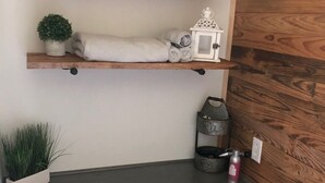 A kitchen with wooden shelves, a potted plant, and a kettle. - Lake front home in quiet neighborhood & mins away from boat launch and amenities (Many)