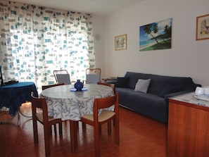 Relax in this inviting living room with a round dining table and comfortable sofa.