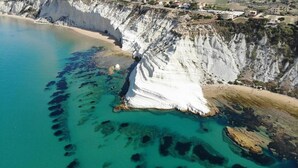 A coastal cliff with a beach and clear blue water. - Room in B&B - Relais Dea Degli Ulivi House (Agrigento)