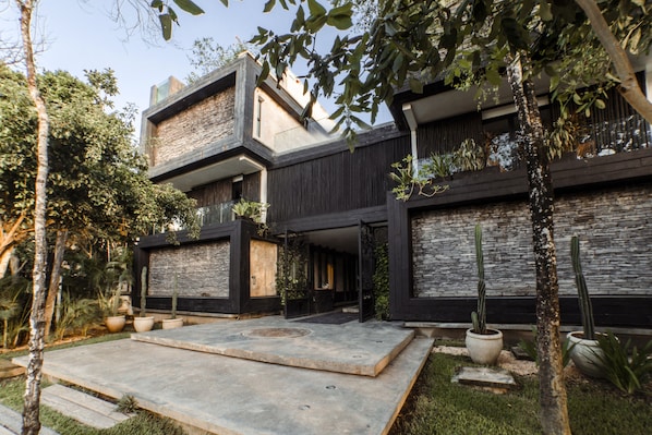 Stunning multi-level building with a contemporary design, featuring a garden and patio area, large windows, and spacious balconies.