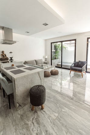 Relax in a spacious living area with a dining table, comfortable sofa, and stylish armchair.