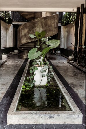 Stroll through this peaceful garden oasis, surrounded by lush greenery and a serene water feature.