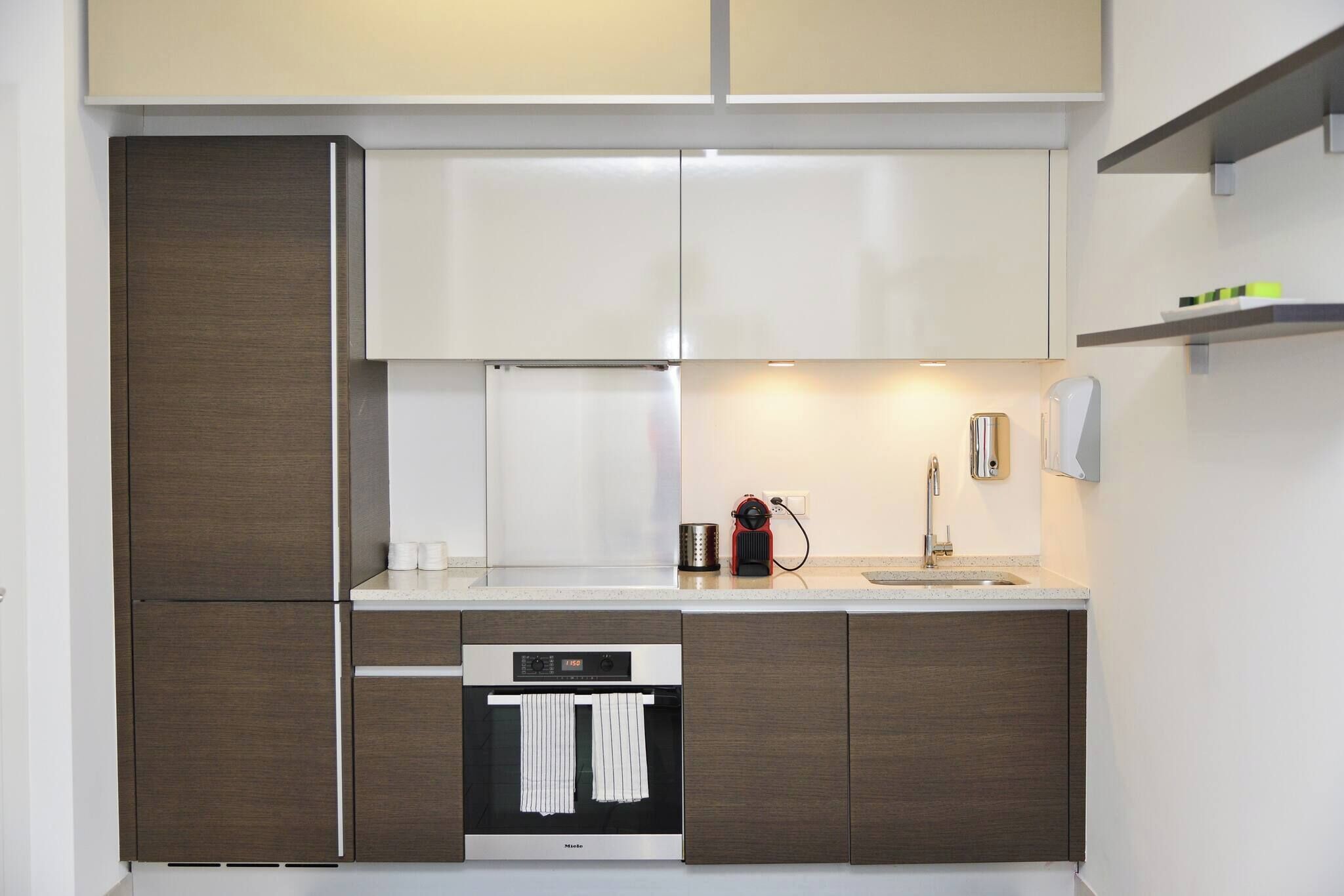A compact kitchen with a built-in oven, a microwave, and a sink.