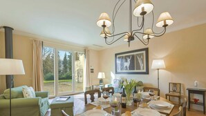 A dining area with a round table set for four, surrounded by chairs. There is a chandelier above the table, and a painting hangs on the wall. - Belvilla by OYO Villa Arnia (Reggello)