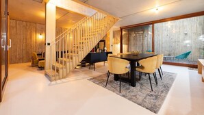 A modern interior with a staircase, dining area, and large windows. - The Victoria Park Sanctuary - Stunning 2bdr Flat (London)