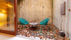 A wooden wall with a glass door, two green chairs, and a small table. - The Victoria Park Sanctuary - Stunning 2bdr Flat (London)