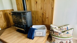 A wood-burning stove, a storage box labeled "HOME", and a decorative cushion with a rural scene. - Country paradise! Close to Telluride (Norwood)