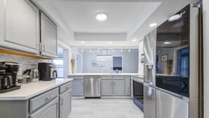 A modern kitchen with stainless steel appliances, white cabinetry, and a central island. - 🏝️10 MINS TO BEACH # HEATED POOL/SPA # SLEEP FOR 12@ KIDS FRIENDLY (Melbourne)
