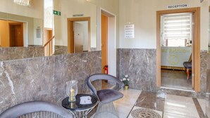 A reception area with marble flooring, a reception desk, and two chairs. - Cozy Corner in Oberhausen (Oberhausen)
