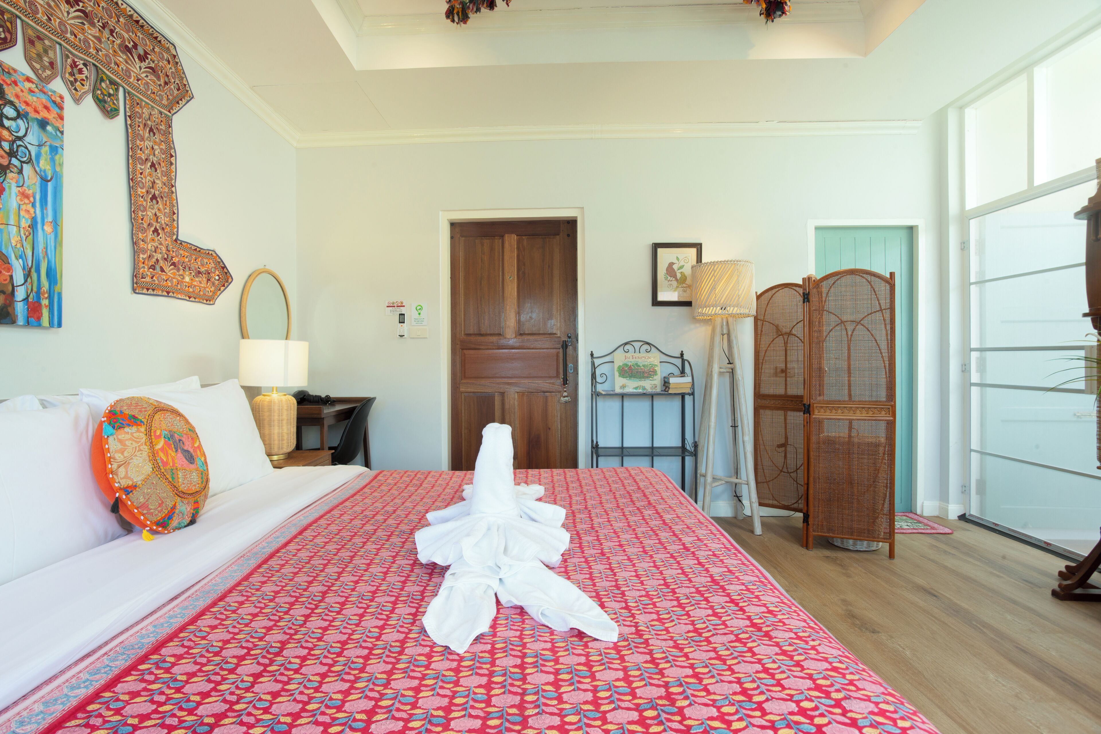 Une chambre d’hôtel avec un grand lit, une porte en bois, une fenêtre et un élément décoratif mural.