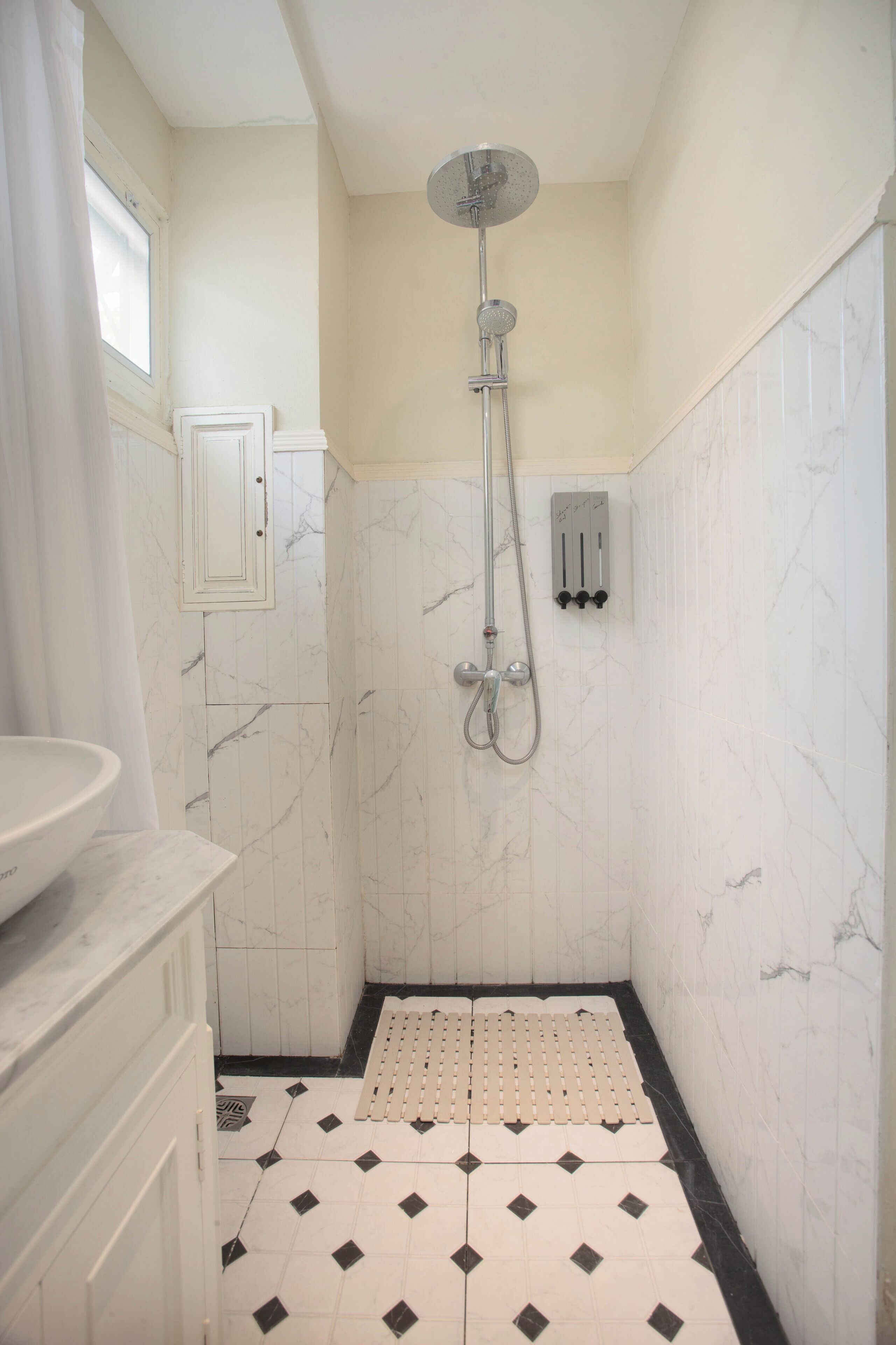 A bathroom with a shower, a sink, and a toilet.