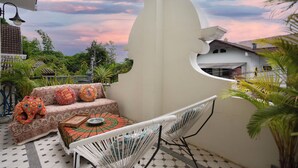 A patio with a sofa, chairs, and a table. - Pran at Kumuang Boutique House (Chiang Mai)