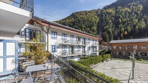 A hotel with outdoor seating, a balcony, and a mountain backdrop. - V Loriaz 14: Beside Ski Lift; Pool, Sauna & Gym, Vallorcine (Argentiere), France (Vallorcine (Argentiere))