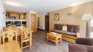 A compact living space with a kitchen, dining area, and a sofa. - V Loriaz 13: Beside Ski Lift; Pool, Sauna & Gym, Vallorcine (Argentiere), France (Vallorcine (Argentiere))