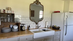 Une cuisine équipée d’un évier, d’une balance et d’un miroir.