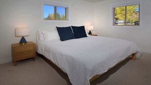 A bedroom with a large bed, two bedside tables, and two windows. - Hidden Gem, Hot tub, Garage, Amazing Views! (Mt. Crested Butte)