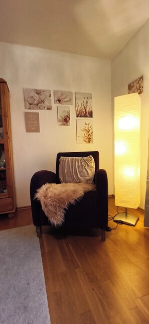 Un salon avec un canapé, une lampe et des œuvres d’art murales.