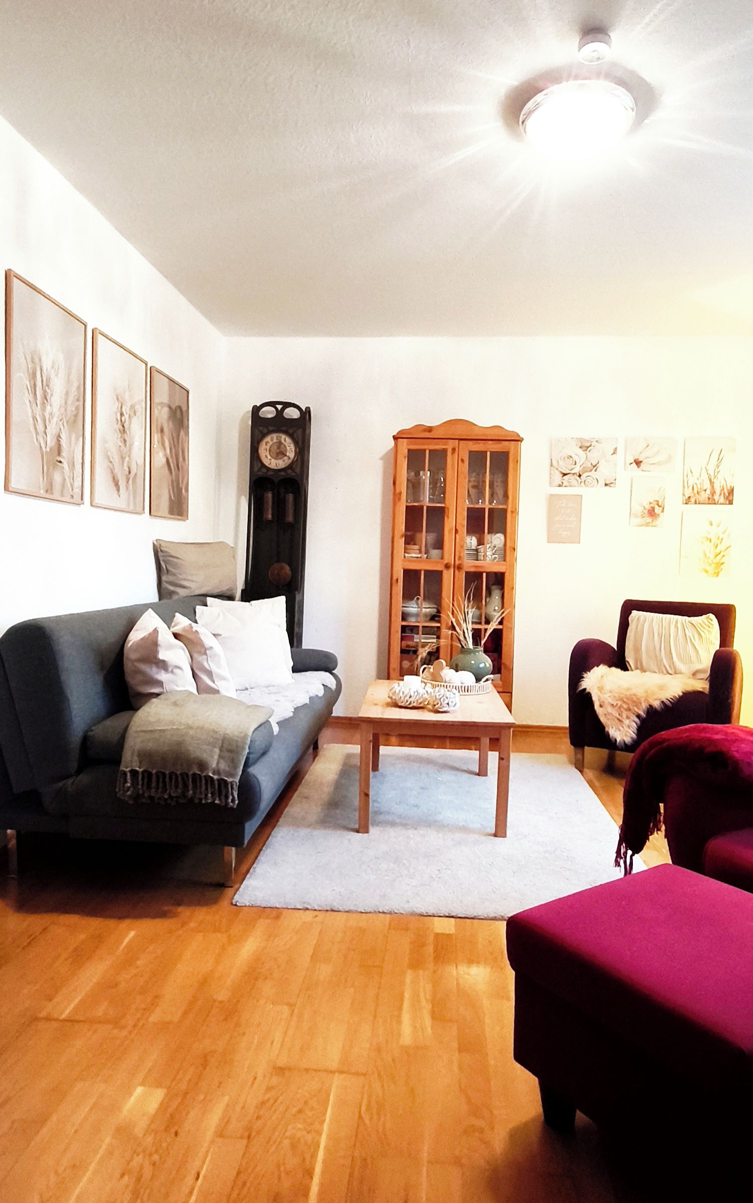 Ein Wohnzimmer mit einer Couch, einem Couchtisch, einem Schrank und einer Wanduhr.