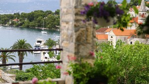 Une ville côtière dotée d’un port de plaisance, de bâtiments en pierre et d’une végétation luxuriante.