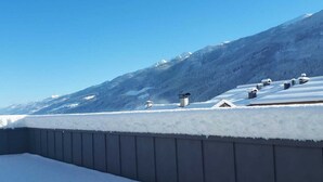 Ein mit Schnee bedecktes Dach mit freiem Blick auf ein Gebirge.