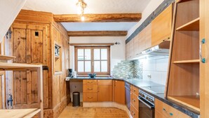 Eine Küche mit Holzausstattung, einem Fenster und einem eingebauten Backofen.