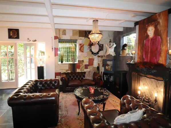 Ein gemütliches Wohnzimmer mit Ledersofas, einem runden Couchtisch und einer Chandelier.
