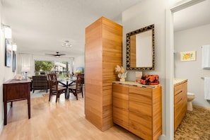 Un interior moderno con comedor, muebles de madera y un baño.