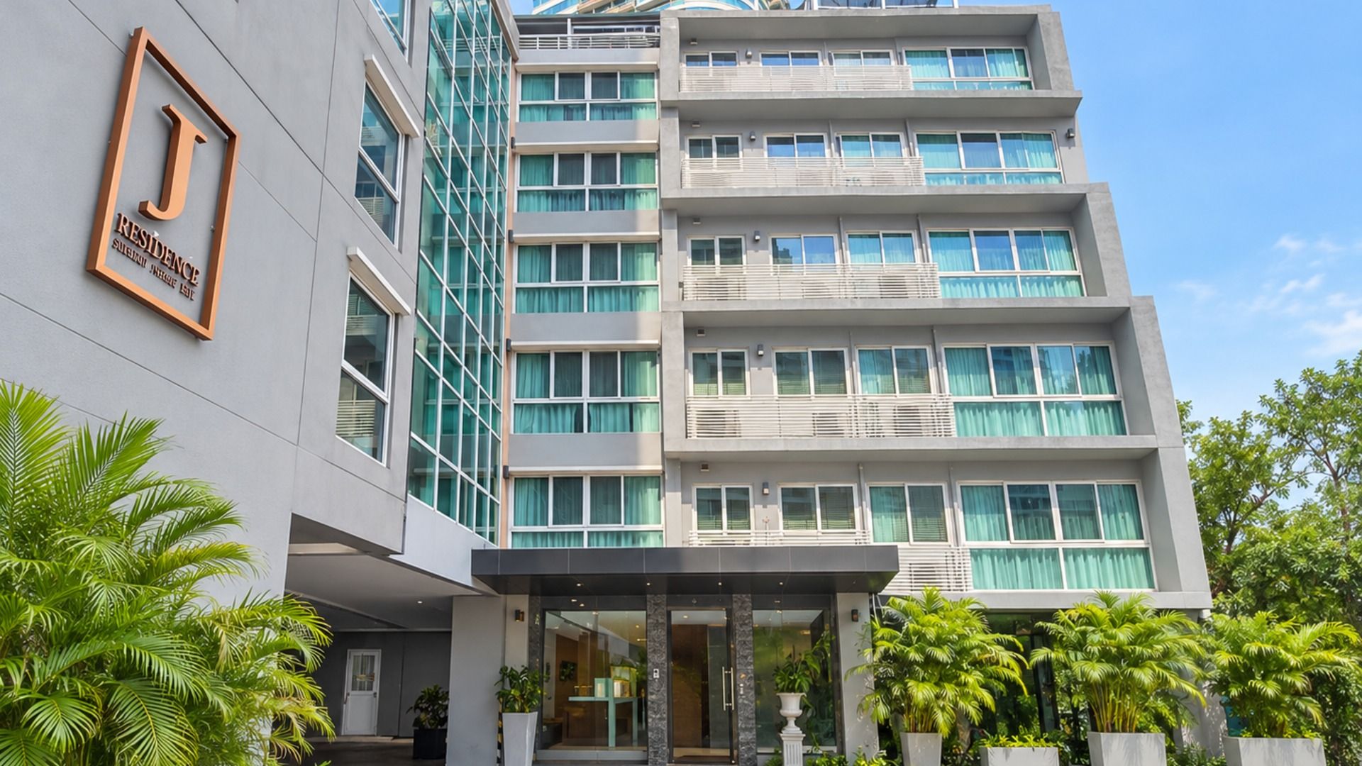 A multi-story hotel with a modern facade, large windows, and a prominent entrance with a glass door.