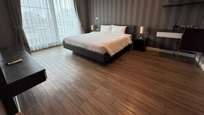 Ein modernes Hotelzimmer mit einem großen Bett, einem Schreibtisch und einem kleinen Badebereich.