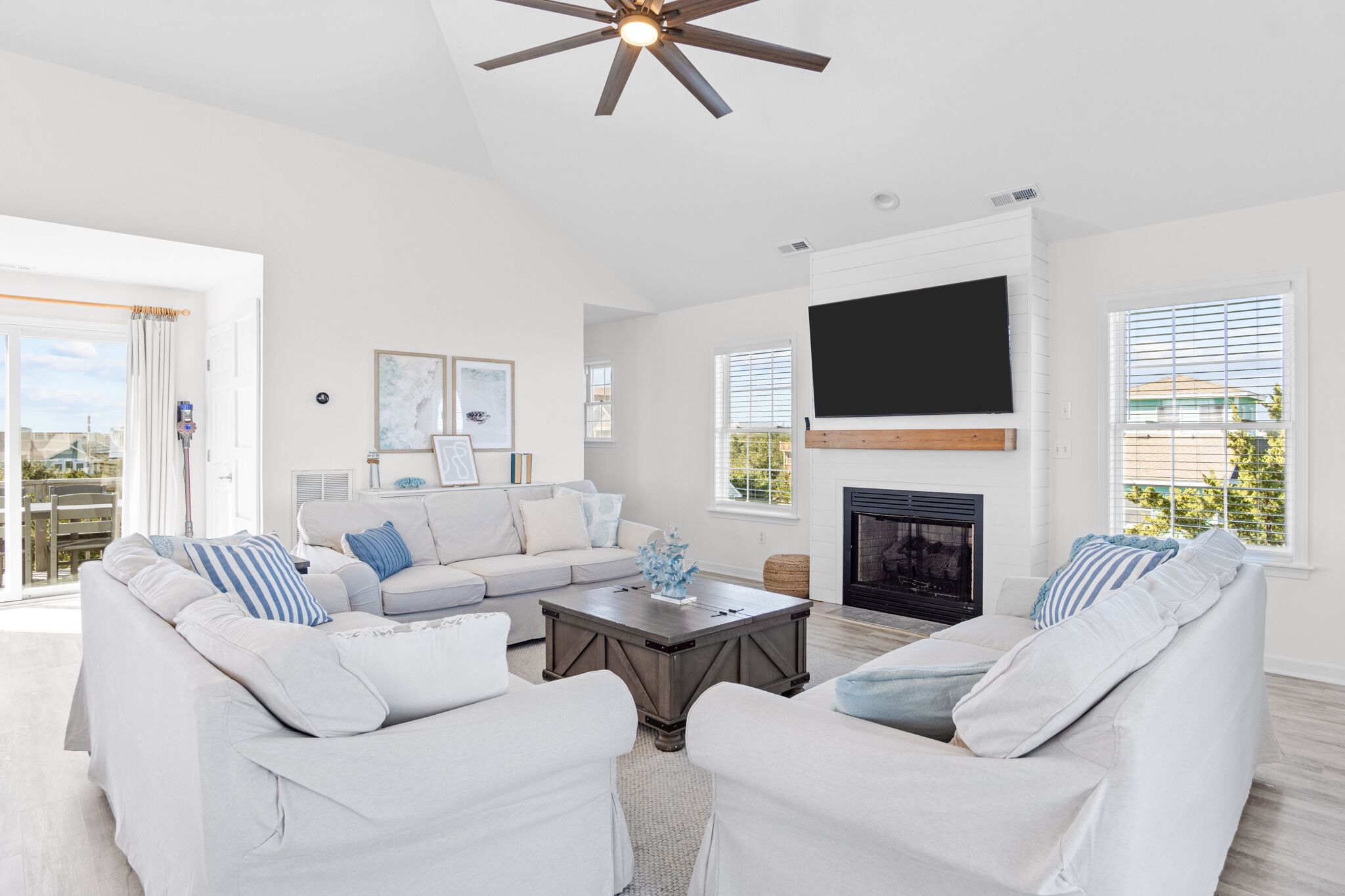 A spacious living room with a large sofa set, a coffee table, and a fireplace.