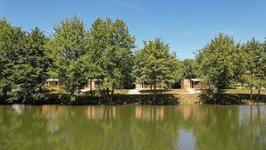 Vista panorámica de un lago con cabañas de madera y cielo despejado.