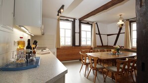 A kitchen with a granite countertop, wooden chairs, and a dining table. - Get-together in Fewo Holunder; celebrations with family and friends (Rosenthal)
