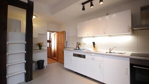 A modern kitchen with white cabinets, a built-in oven, and a sink. - Get-together in Fewo Holunder; celebrations with family and friends (Rosenthal)