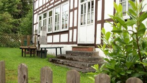 A traditional half-timbered building with a stone bench and steps leading to the entrance. - Get-together in Fewo Holunder; celebrations with family and friends (Rosenthal)