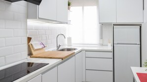 A modern kitchen with white cabinets, a stainless steel sink, a built-in oven, and a refrigerator. - Spacious & Renovated 2BR Apt with Parking, Near Calle Laurel, Logroño (Logroño)